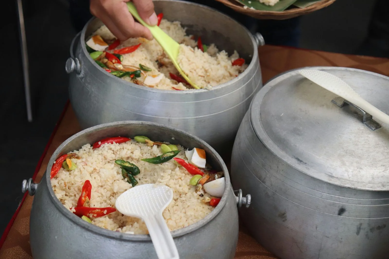 Pots of spiced rice with chillies, petai, anchovies and salted egg, ready to serve